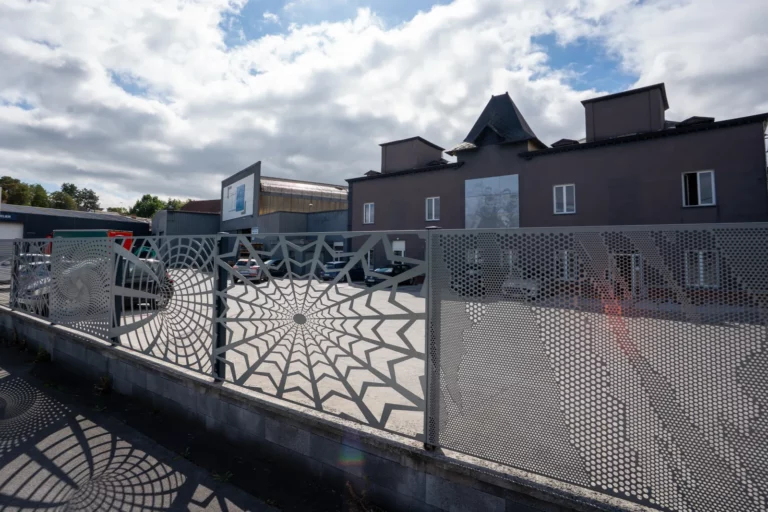 Decorative perforated and cut sheet fence in front of the TPS site
