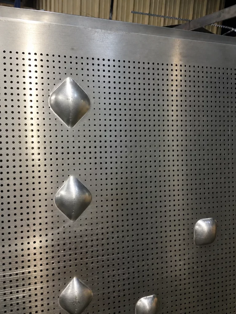 Detail van de diepgetrokken vormen op een geperforeerde aluminium plaat